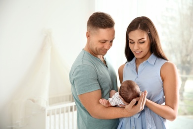 Photo of Happy couple with their newborn baby at home. Space for text