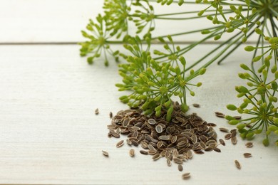 Dry seeds and fresh dill on white wooden table, closeup. Space for text