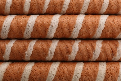 Tasty wafer roll sticks as background, top view. Crispy food