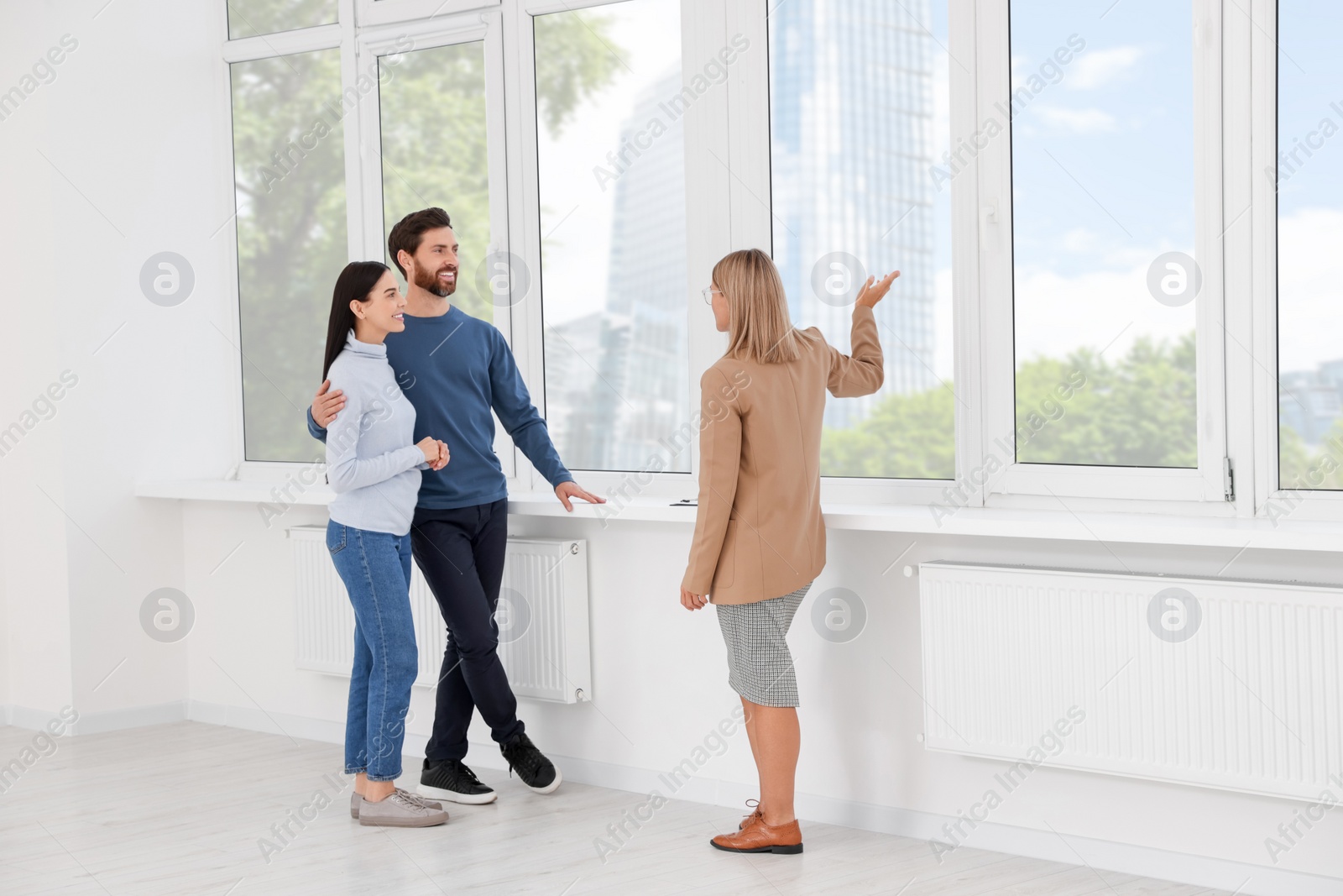 Photo of Real estate agent showing new apartment to couple