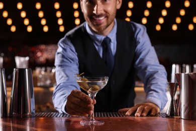 Photo of Bartender with fresh alcoholic cocktail in bar, selective focus