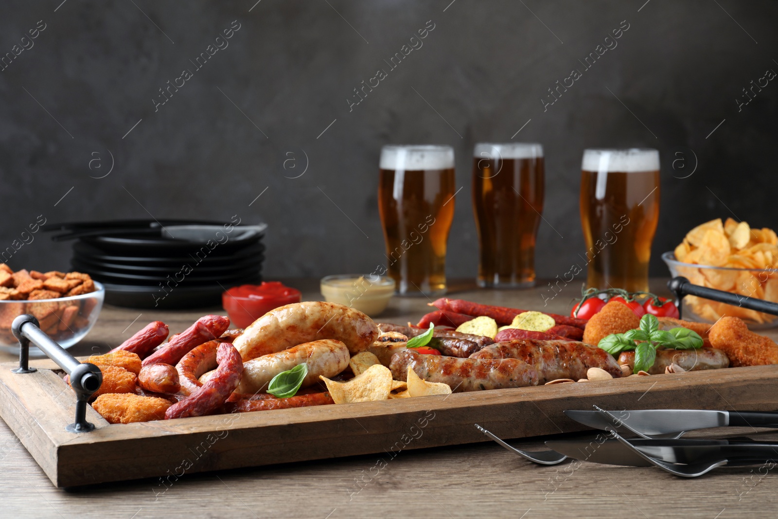 Photo of Set of different tasty snacks and beer on wooden table