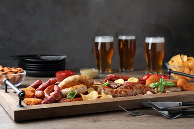 Set of different tasty snacks and beer on wooden table