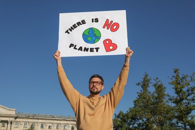 Photo of Man with poster protesting against climate change outdoors