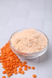 Bowl of lentil flour and seeds on white tiled table