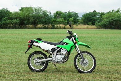 Stylish cross motorcycle on green grass outdoors