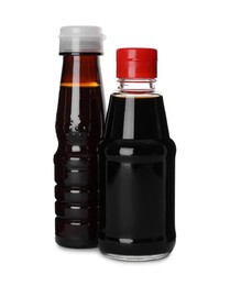 Photo of Bottles of tasty soy sauce isolated on white