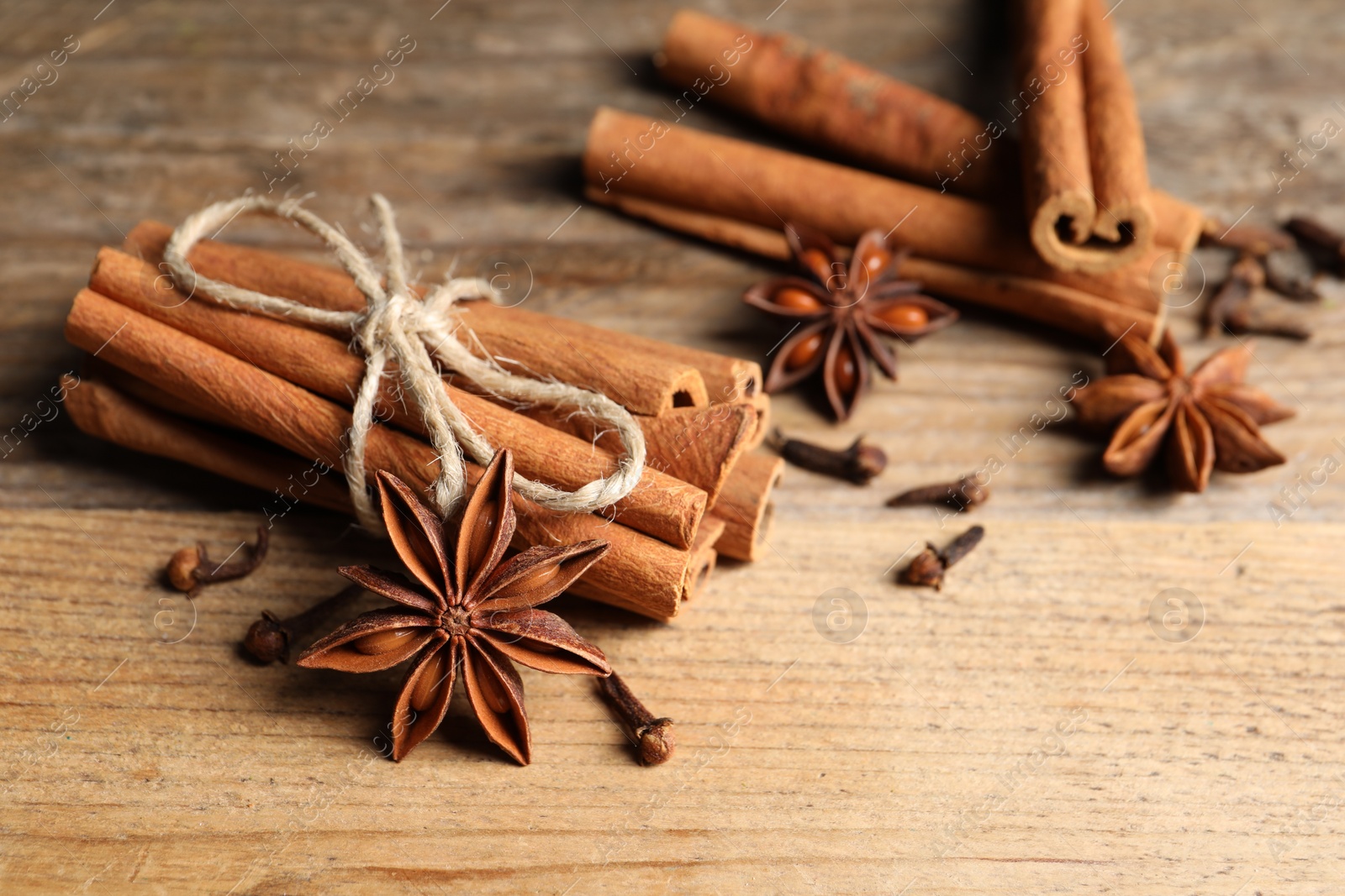 Photo of Different aromatic spices on wooden table, closeup