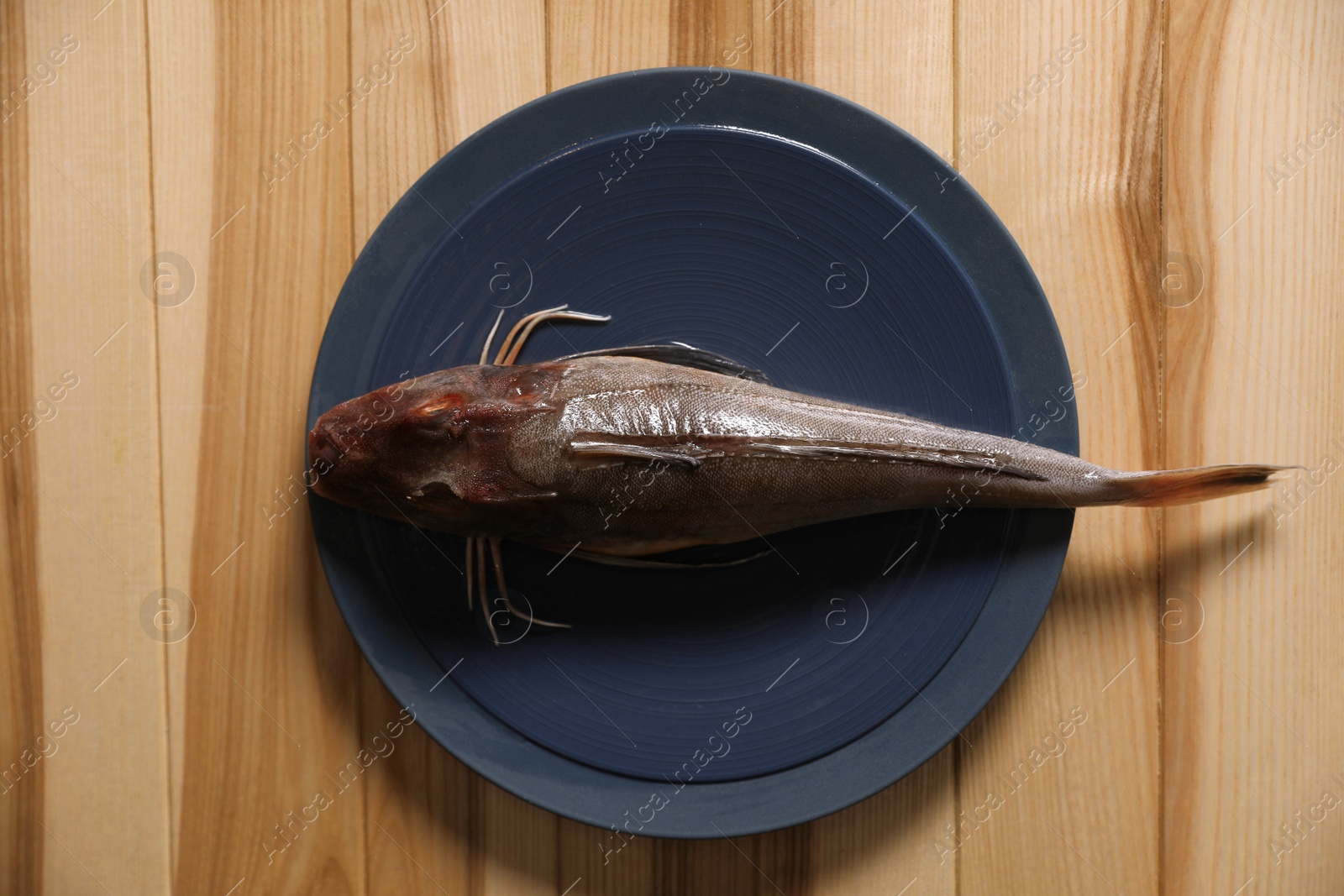 Photo of Fresh raw fish on wooden table, top view