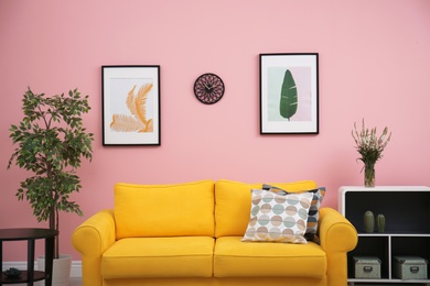 Photo of Modern living room interior with comfortable yellow sofa near color wall