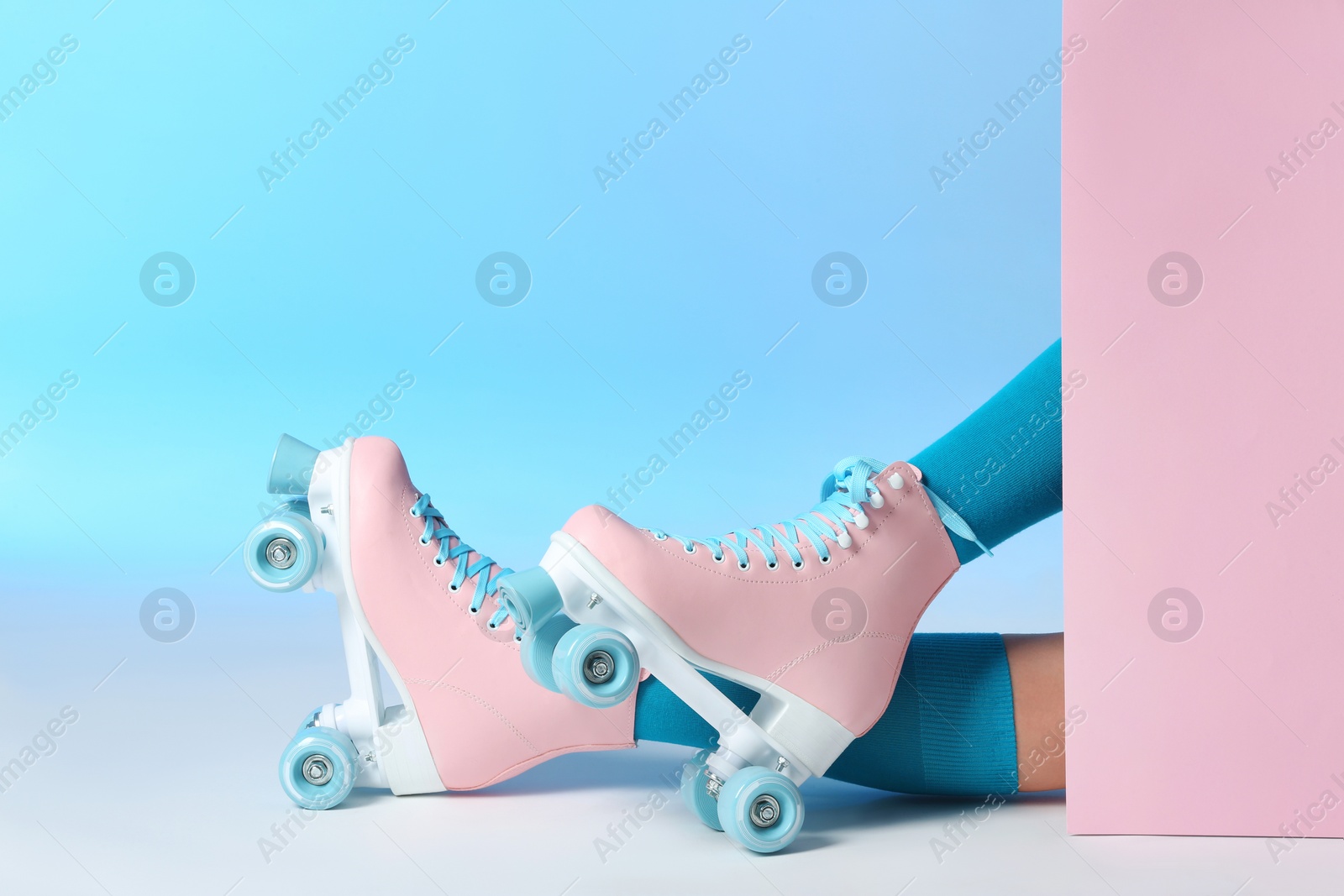 Photo of Woman with vintage roller skates on color background, closeup. Space for text