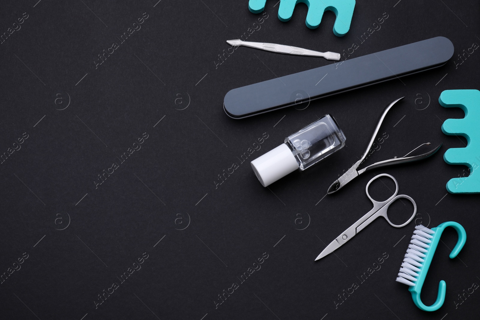 Photo of Set of pedicure tools on black background, flat lay. Space for text