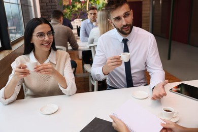 Photo of Coworkers enjoying coffee during break in cafe