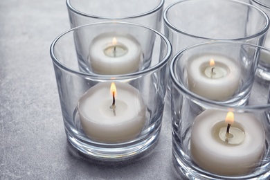 Photo of Beautiful burning wax candles in glasses on table