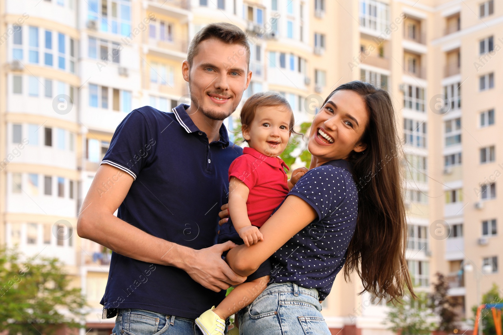 Photo of Happy family with adorable little baby outdoors