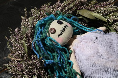 Female voodoo doll with pins on wreath, closeup