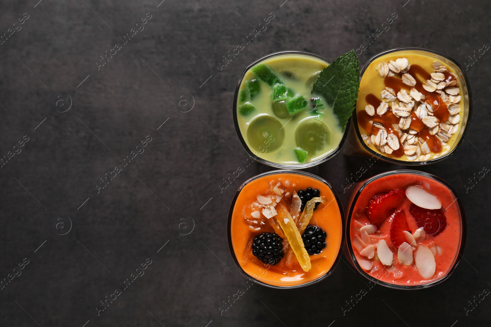 Photo of Many different delicious smoothies on grey table, flat lay. Space for text