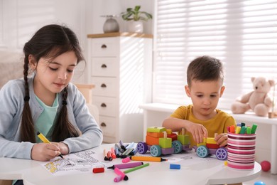Photo of Cute children coloring drawing and playing at table in room