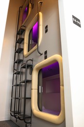 Capsules in modern pod hostel, low angle view. Stylish interior