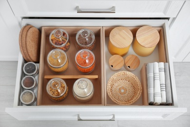 Photo of Open drawer with different jars indoors. Order in kitchen