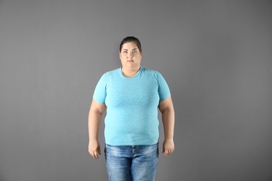 Portrait of overweight woman on gray background
