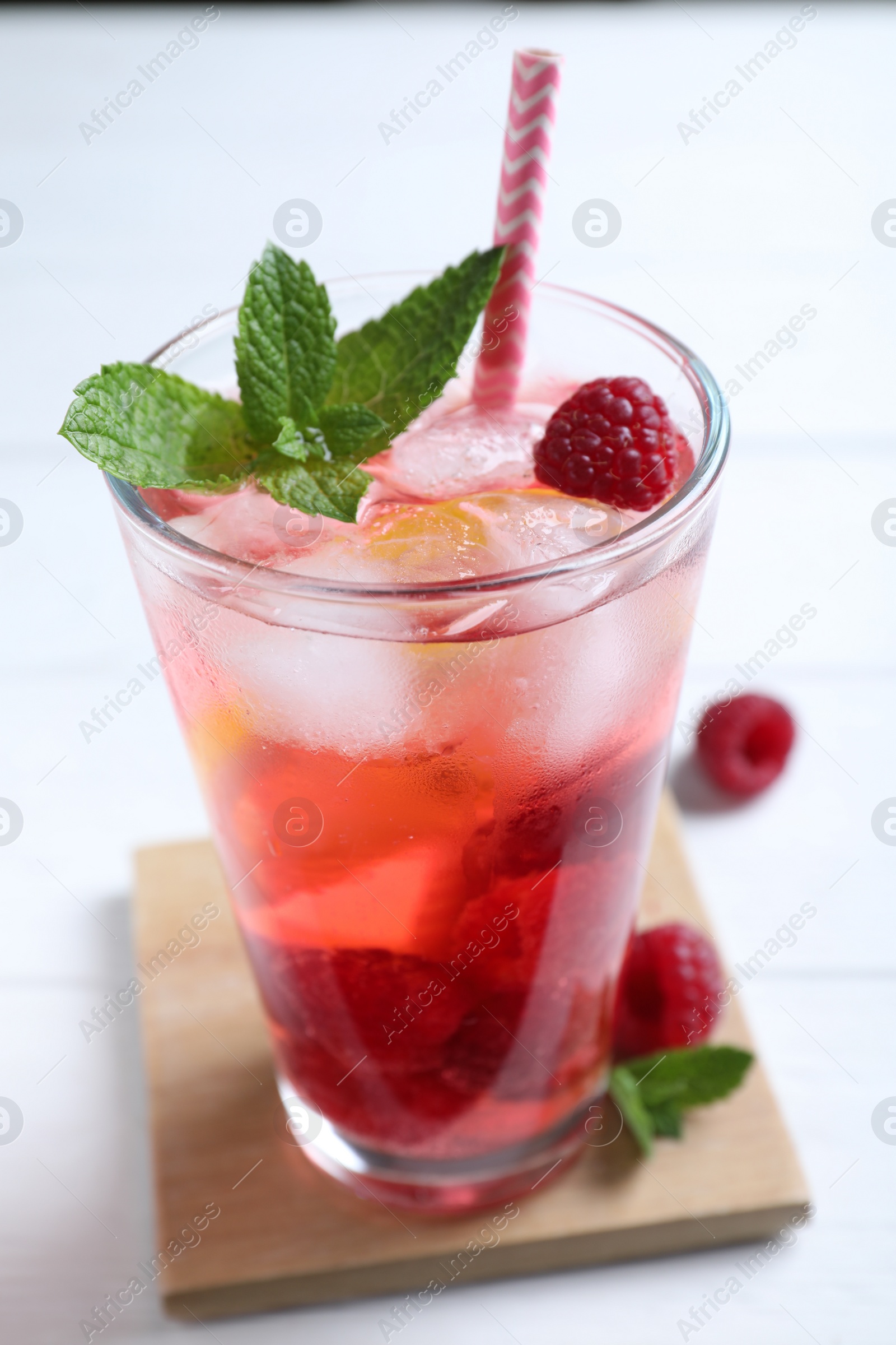 Photo of Delicious raspberry lemonade made with soda water on white wooden table