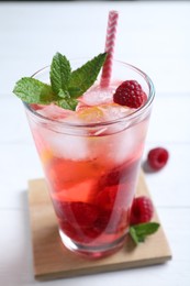 Photo of Delicious raspberry lemonade made with soda water on white wooden table