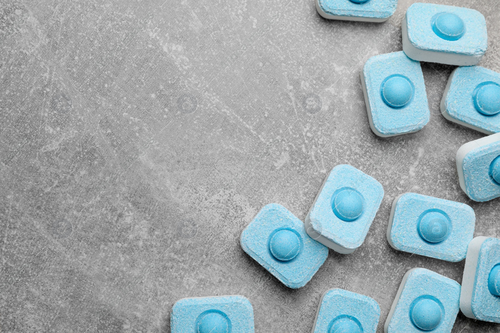 Photo of Water softener tablets on grey table, flat lay. Space for text