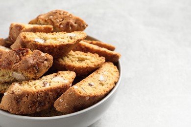 Traditional Italian almond biscuits (Cantucci) in bowl on light table, closeup