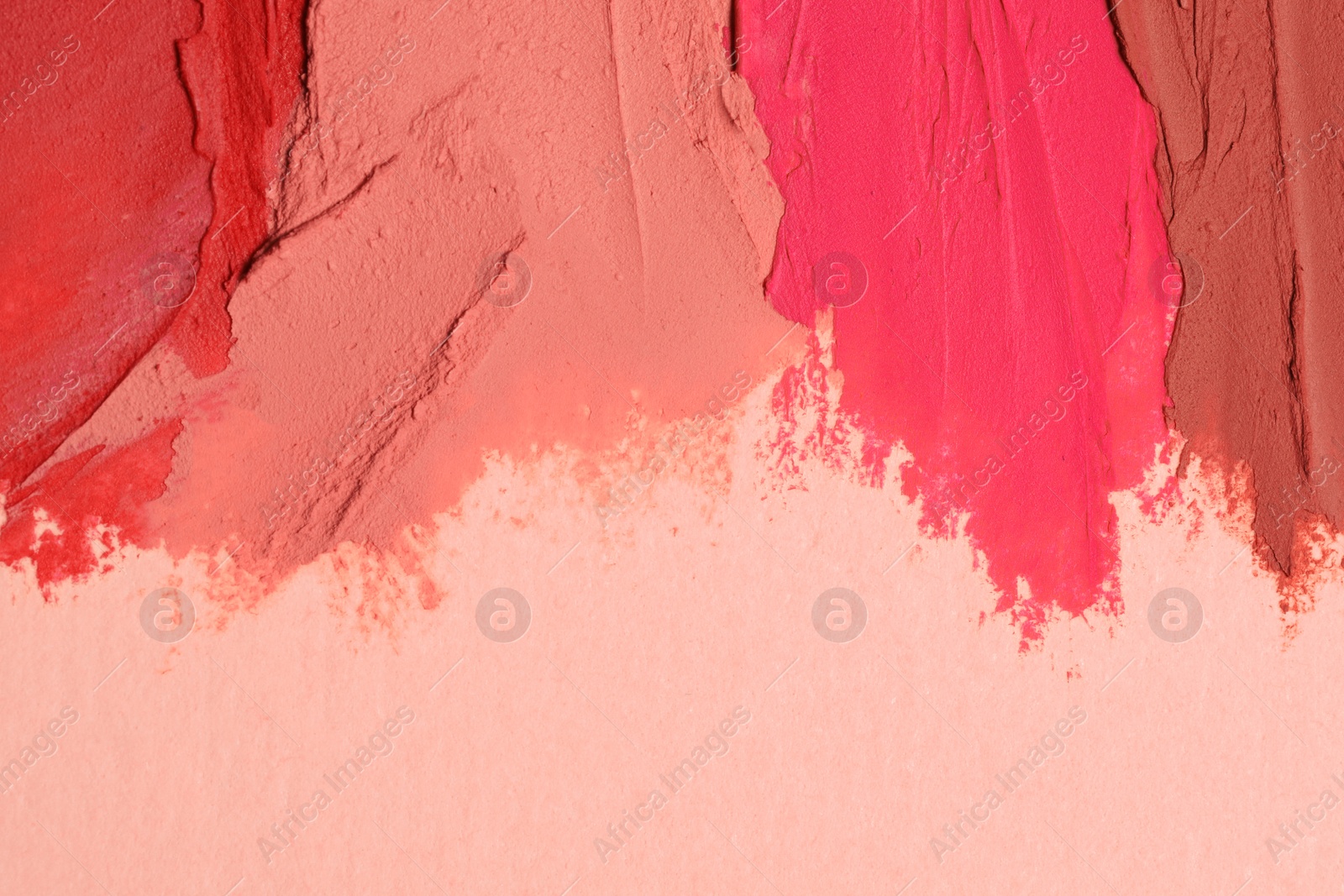 Photo of Smears of beautiful lipsticks on beige background, top view. Space for text