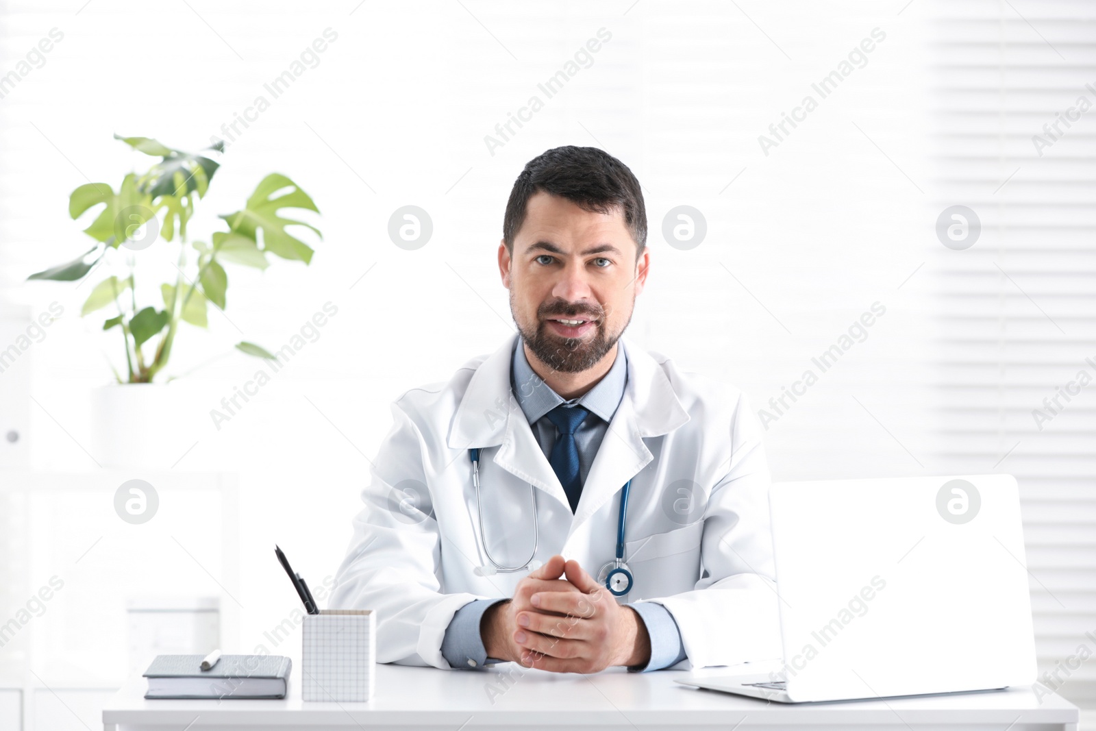 Photo of Portrait of male doctor in white coat at workplace