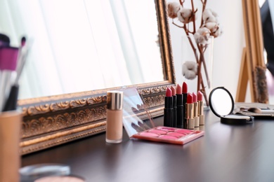 Photo of Decorative cosmetics on dressing table in makeup room
