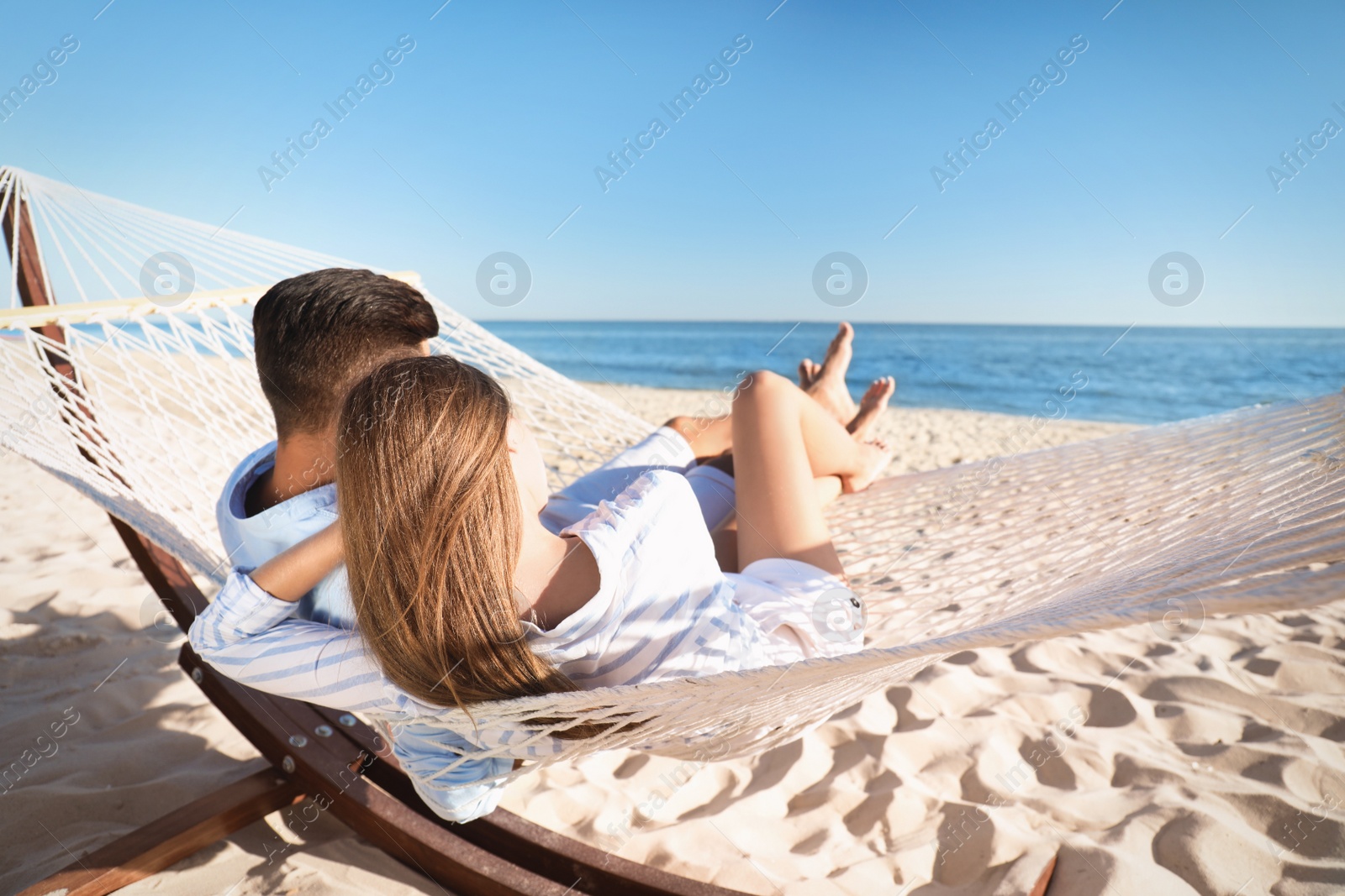 Photo of Couple relaxing in hammock on beach. Summer vacation