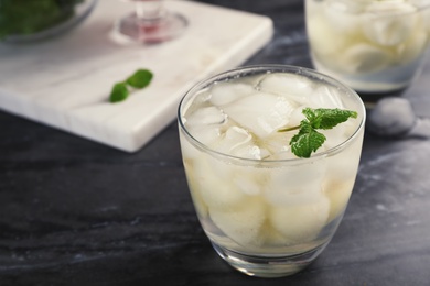 Photo of Glass with tasty melon ball drink on dark table