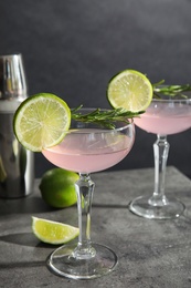 Tasty refreshing lime cocktail with rosemary on table