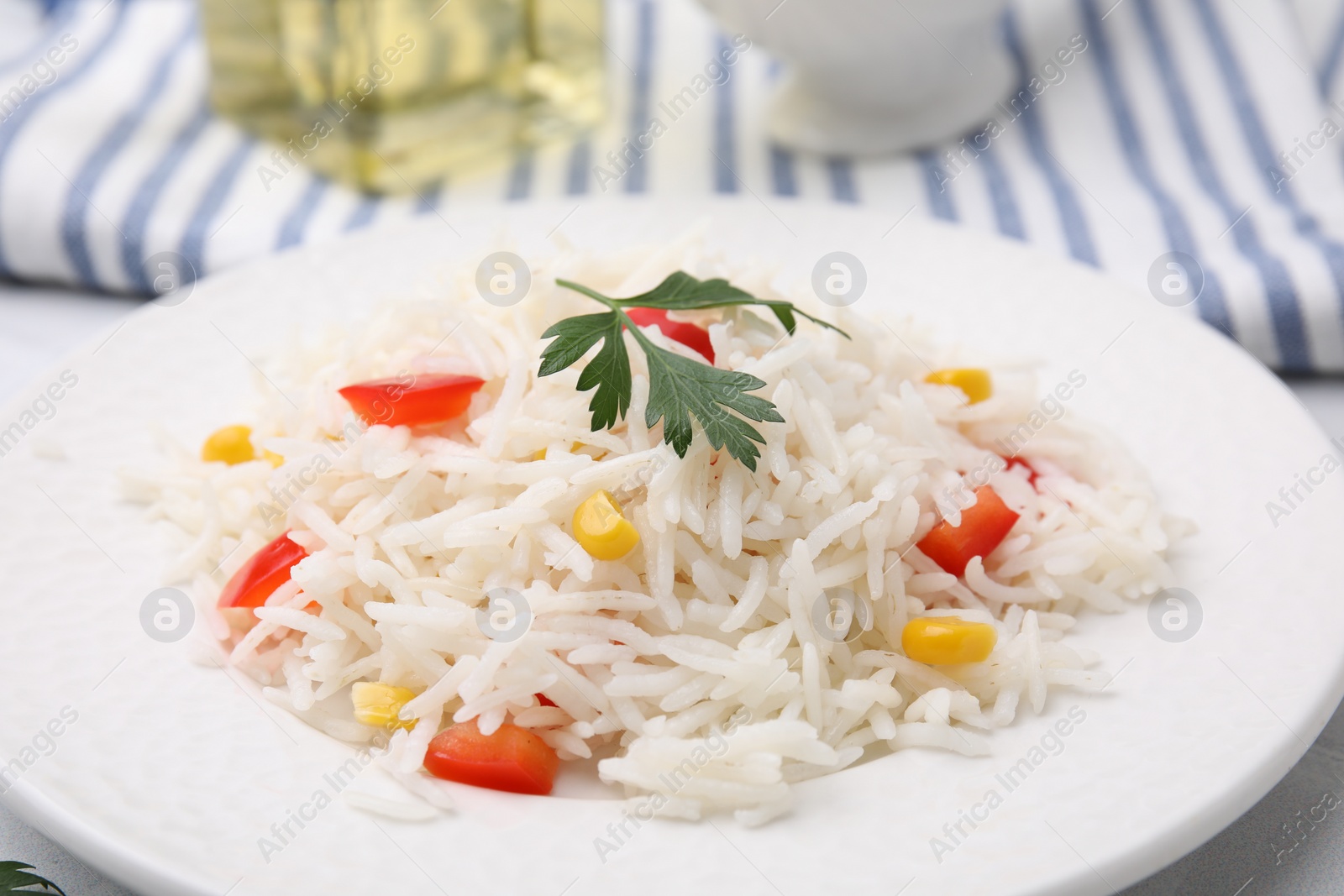 Photo of Plate of delicious rice with vegetables and parsley on table, closeup