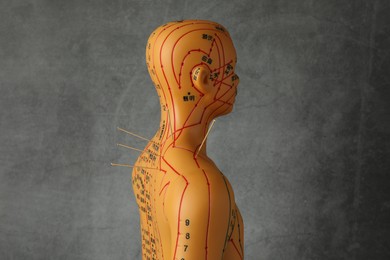 Photo of Acupuncture - alternative medicine. Human model with needles in shoulder against dark grey background