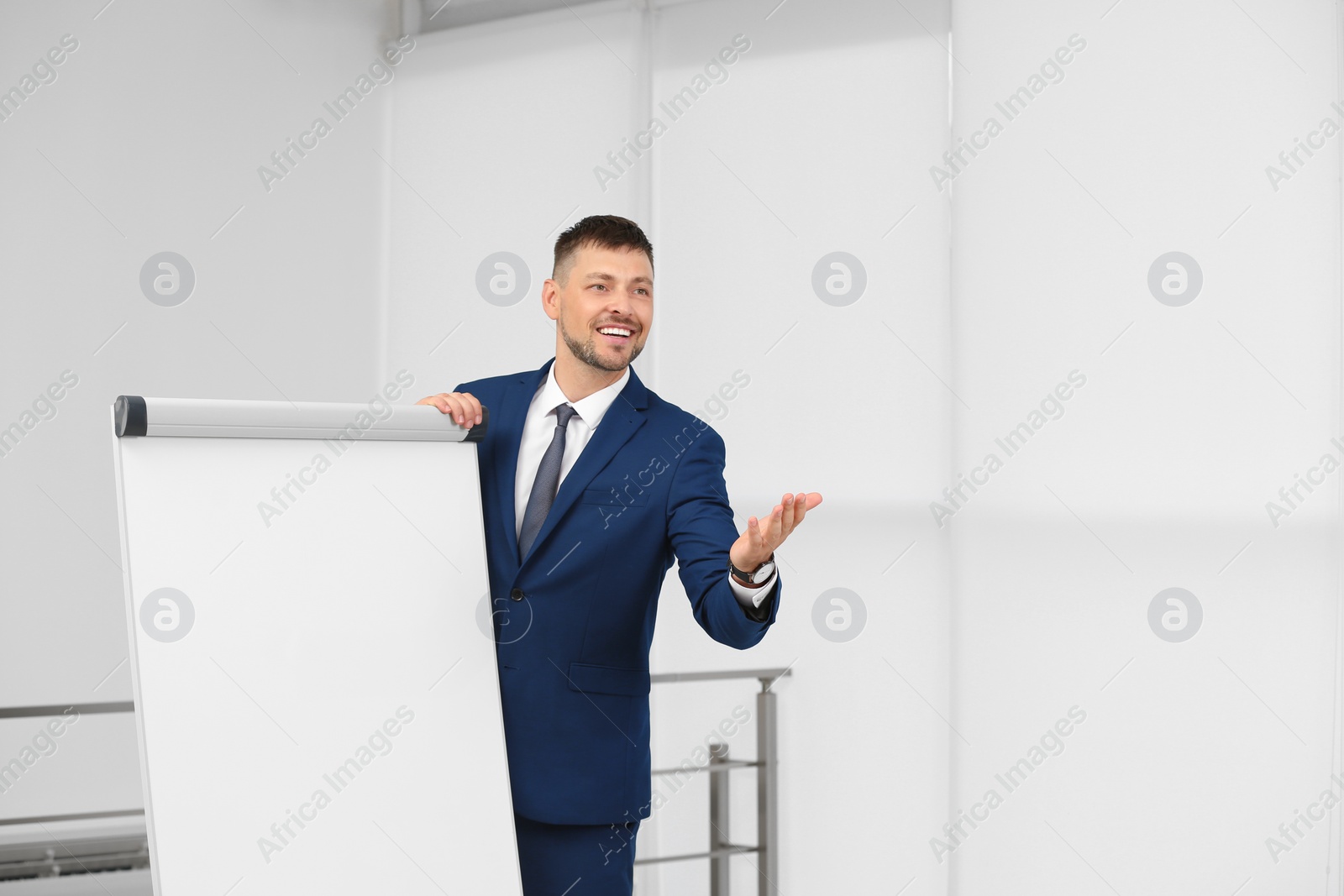 Photo of Professional business trainer near flip chart board indoors. Space for text