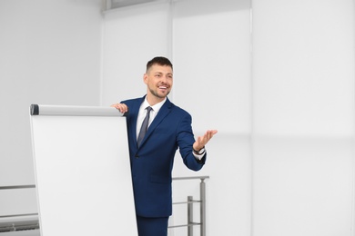 Photo of Professional business trainer near flip chart board indoors. Space for text