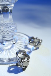 Photo of Stylish presentation of elegant earrings on color background, closeup