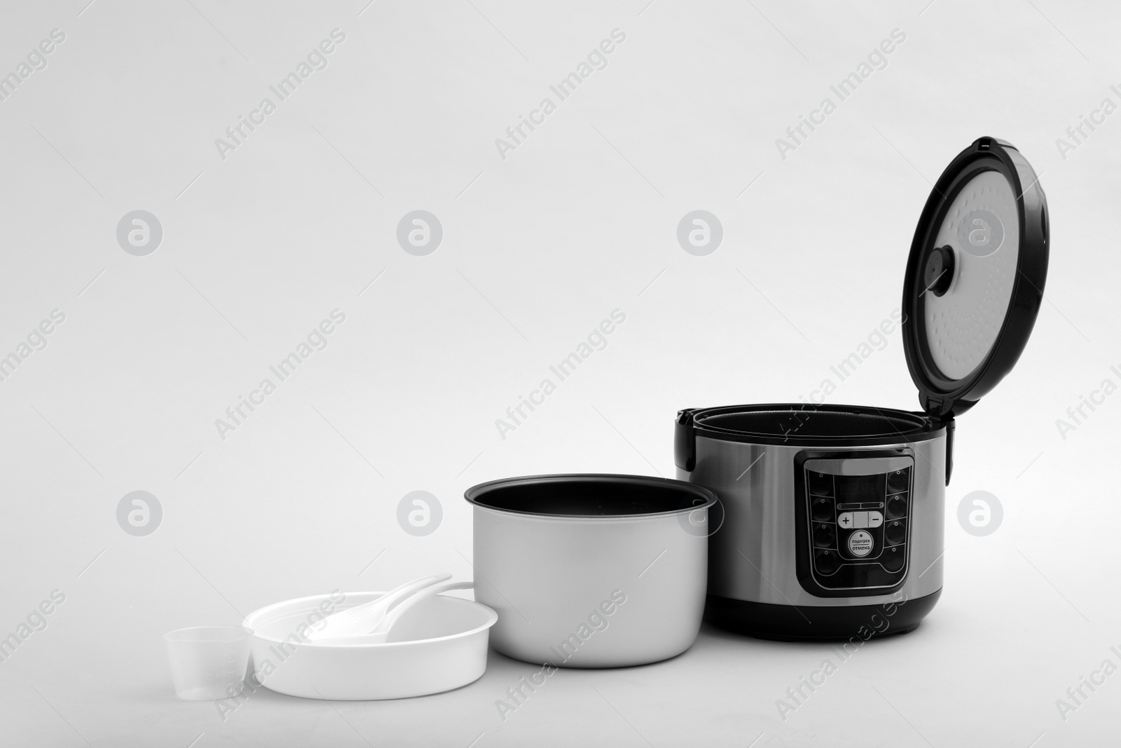 Photo of Modern electric multi cooker, parts and accessories on grey background. Space for text