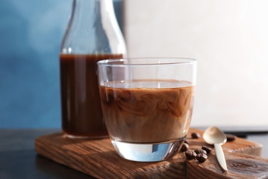 Photo of Glass with cold brew coffee and milk on wooden board