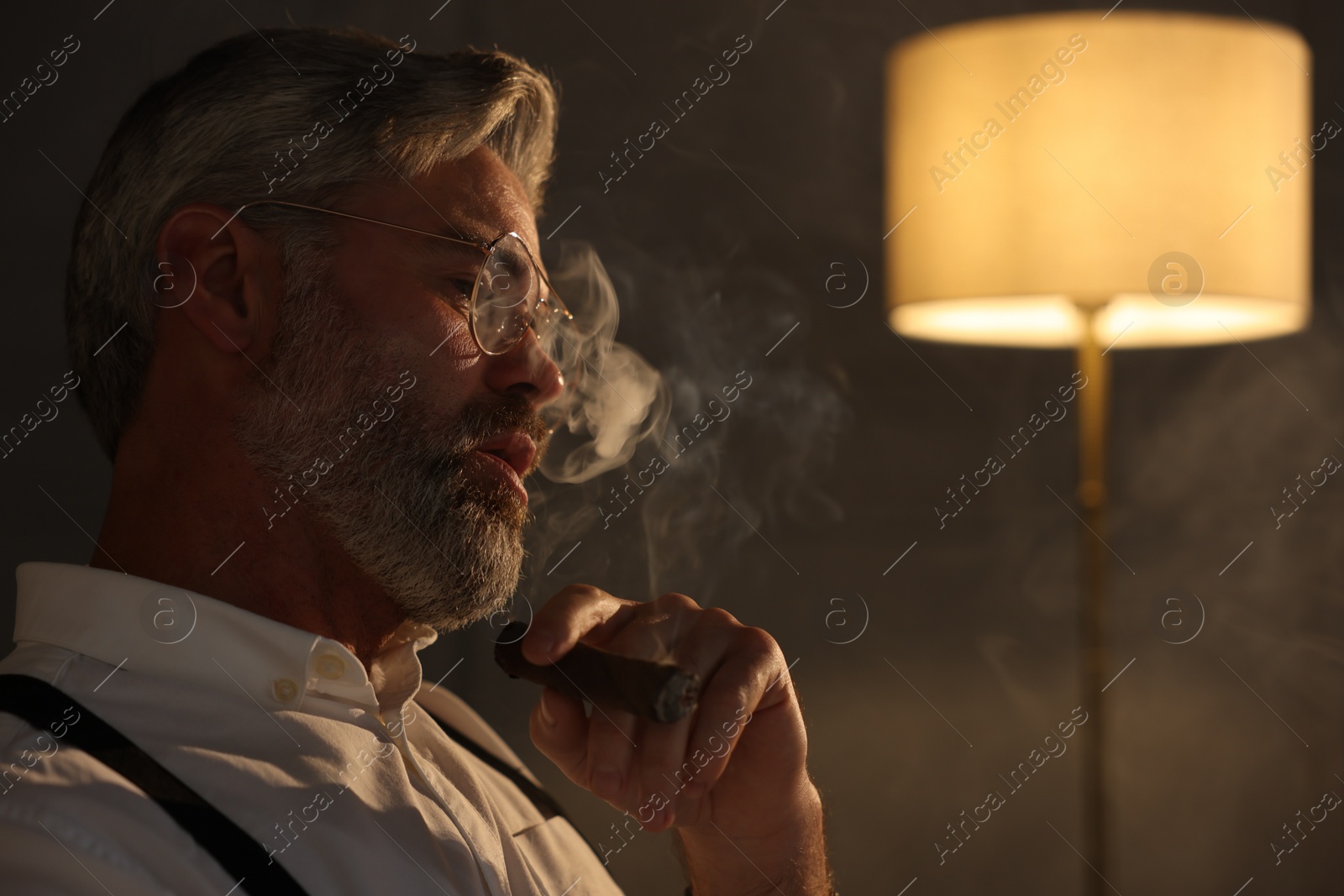 Photo of Bearded man smoking cigar indoors. Space for text