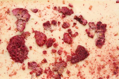 Chocolate bar with freeze dried raspberries as background, closeup