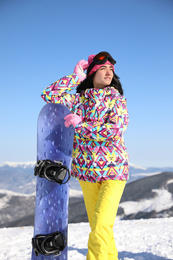 Photo of Young woman with snowboard outdoors. Winter vacation