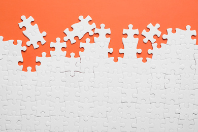Photo of Blank white puzzle pieces on orange background, flat lay