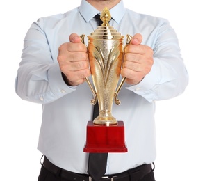 Photo of Young businessman holding gold trophy cup on white background, closeup
