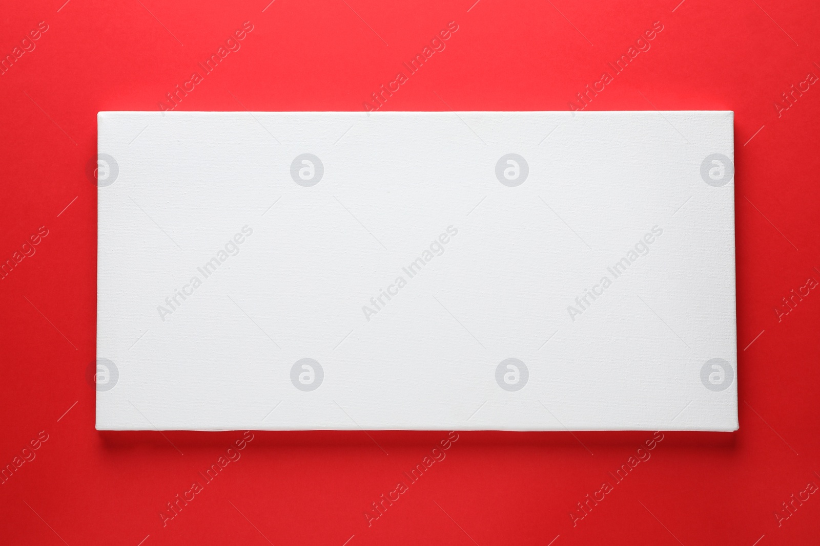 Photo of Blank canvas on red background, space for text