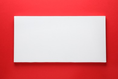 Photo of Blank canvas on red background, space for text