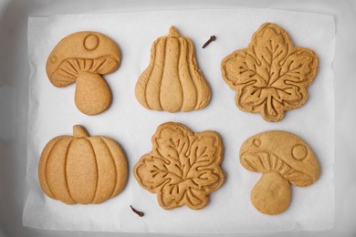 Photo of Different tasty cookies on white parchment, flat lay
